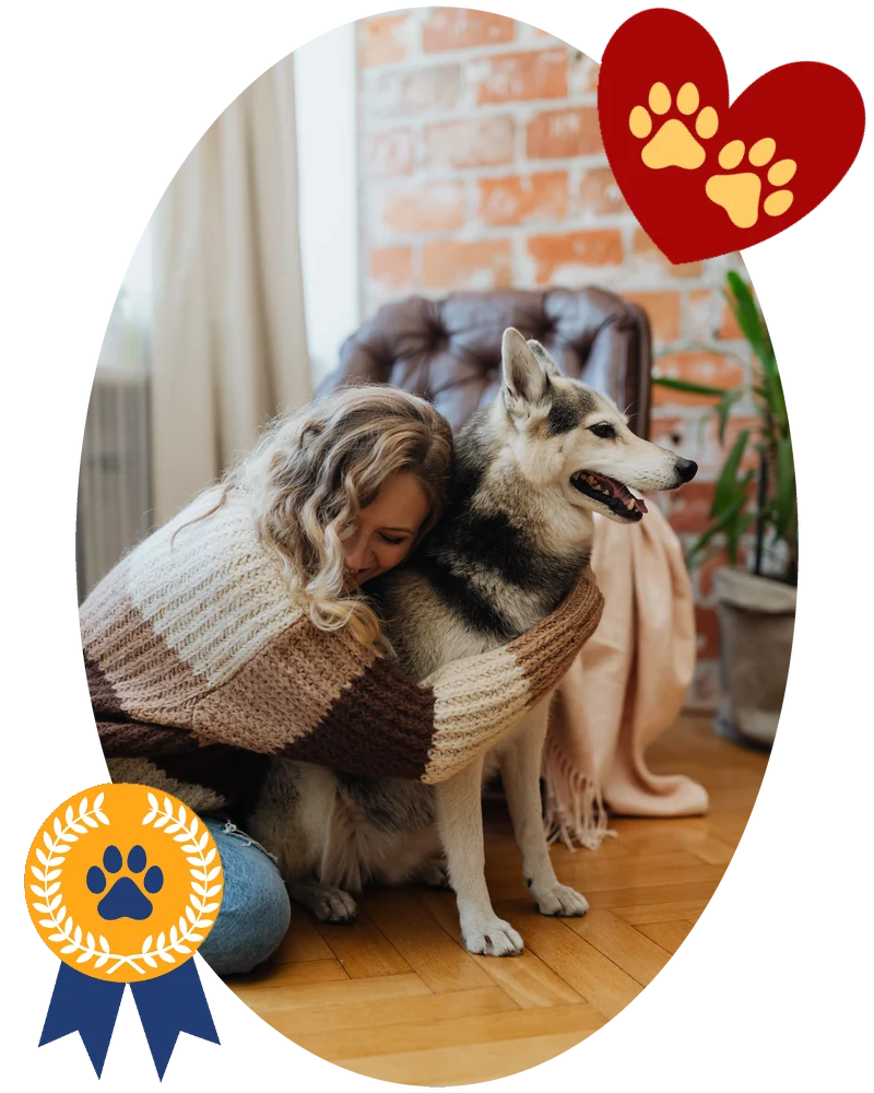 A woman wrapped in a knit blanket hugging her husky at home